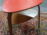 une table au plateau rouge posée sur un tapis