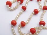 pearl and coral bead necklace on a white background
