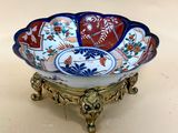 a close up of a decorative bowl on a stand on a table