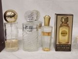 several bottles of perfume are lined up on a white surface
