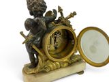 a statue of a boy sitting on top of a clock