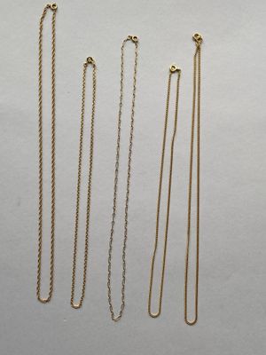 quatre colliers à chaînes en or sur fond blanc