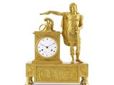 une horloge en or surmontée d'une statue