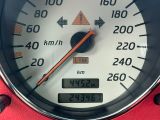 un gros plan d'un compteur de vitesse sur un fond rouge