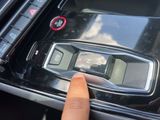 a person pressing a button on a car ' s dashboard