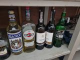 many bottles of alcohol sitting on a shelf next to each other