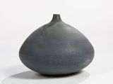 a gray vase that is sitting on a white surface