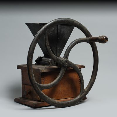 un vieux moulin à café posé sur une caisse en bois