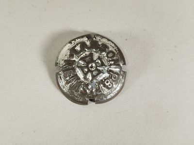 une pièce d'argent sur laquelle figure une image sur un fond blanc