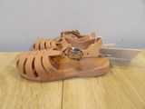 beige sandals on a wooden table with a white tag on it