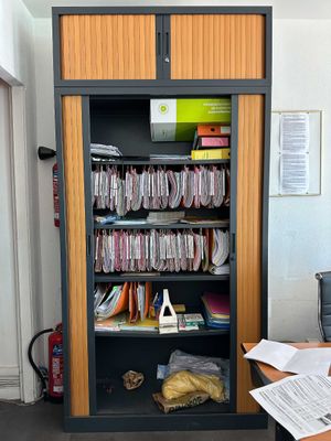 une bibliothèque remplie de livres et de papiers dans une pièce