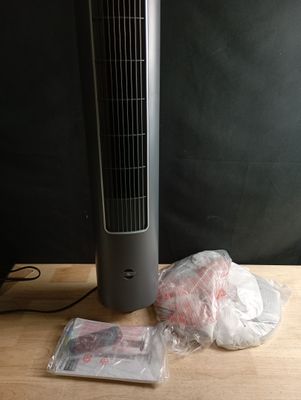 un ventilateur posé sur une table à côté d'un sac de provisions