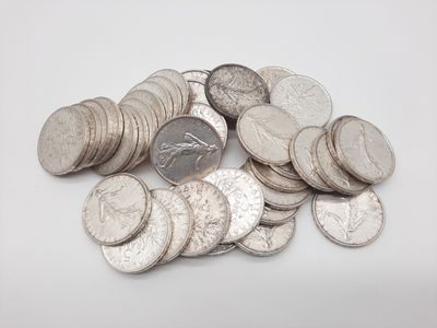 une pile de pièces d'argent empilées les unes sur les autres sur une surface blanche
