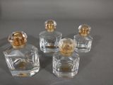 three small glass bottles with gold lids sitting on a table