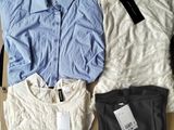 trois chemises et pantalons posés sur un carton