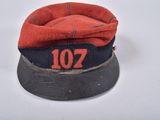 an old red and blue hat with the number 107 on it