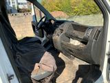 une camionnette blanche avec un siège noir et un sac noir à l'arrière