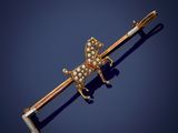 une broche en forme de papillon en or et diamants sur fond bleu