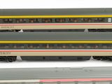 three model trains sitting next to each other on a white surface