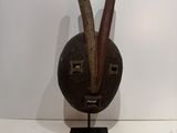 an image of a sculpture of a face with two horns sticking out of it ' s mouth