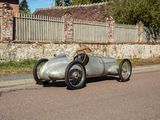 a silver race car that is parked on the side of the road