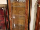 a tall wooden cabinet with glass doors in a room