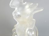 une figurine en verre transparent surmontée d'un oiseau