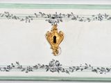 a gold door handle on a white and green painted dresser