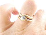 a person holding a ring with a diamond on it
