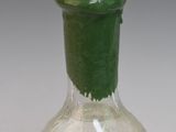 a small bottle with a green lid on a table