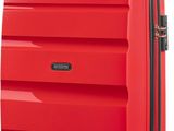 red suitcase with black handle and wheels on a white background