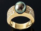 an image of a black pearl and diamond ring on a black surface