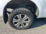 a white truck with a flat tire parked in a parking lot