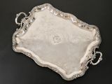 a silver tray with handles and handles on a black surface