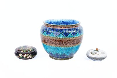 un vase bleu posé à côté d'une petite boîte sur une surface blanche
