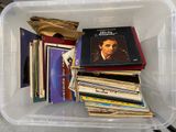 un bac en plastique rempli d'une multitude de disques vinyles