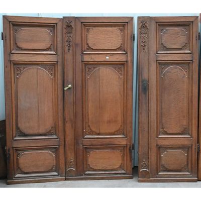 trois portes anciennes en bois ornées de sculptures élaborées en haut et en bas