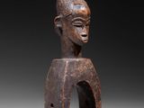 a wooden statue of a man with a hat on his head