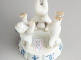 three figurines of cats sitting on top of a plate