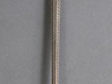 an old silver spoon with a handle on a gray surface