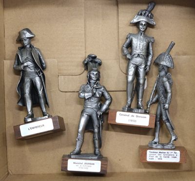 four statues of men in different poses in a cardboard box