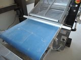 a machine that has a blue sheet on the conveyor belt