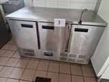 two stainless steel refrigerators in a kitchen with tile flooring