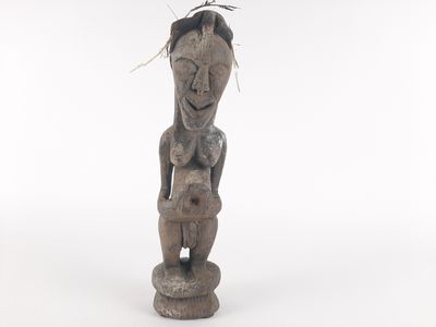 an old wooden statue of a woman with a bird on top of her head