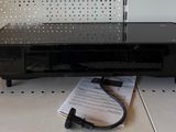 une photo d'un téléviseur posé sur une étagère, avec une télécommande
