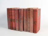 several old books are stacked on top of each other on a white surface