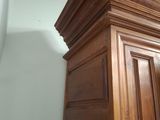 an image of a wooden cabinet in a corner of a room