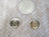 three coins sitting on top of a woven table next to a coin