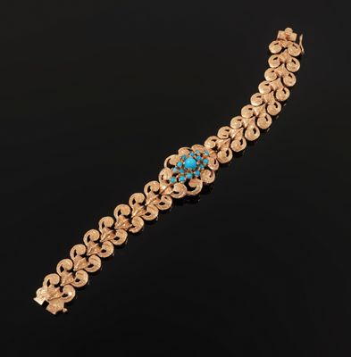 a gold bracelet with a turquoise stone in the center
