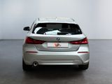 the rear end of a silver bmw car in a white room